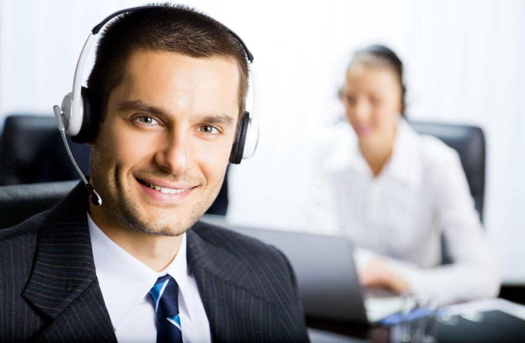 Portrait of happy smiling customer support phone operator in headset at office